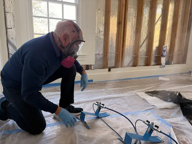A restoration technician setting drying equipment in a Salt Lake City home stripped to the studs